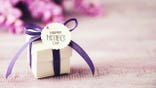 Mother's Day gift box with purple ribbon and wisteria bouquet