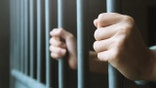 Man in prison bars cell