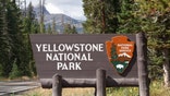 Cooke City, USA - September 17, 2011: Yellowstone National Park Sign (U.S. National Park Service) along the North East Entrance Road. With the beautiful nature of Yellowstone in the background