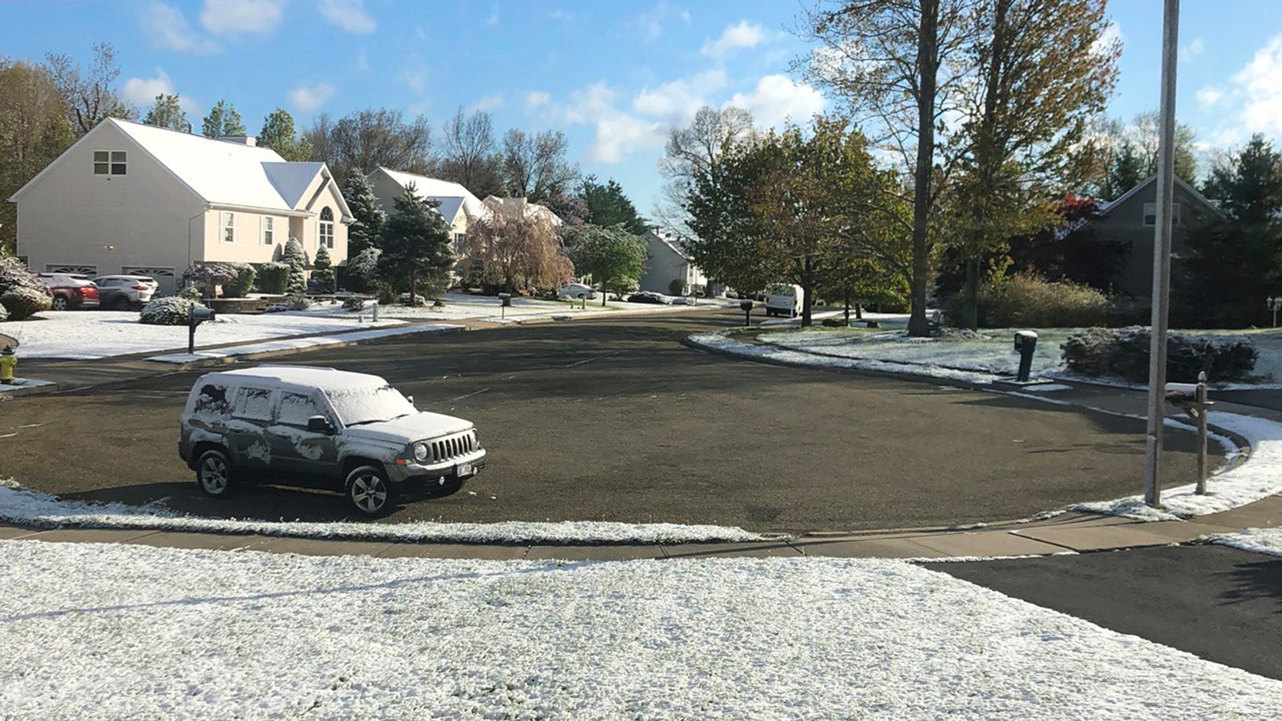 In this photo provided by Robert Beretta, snow accumulates on the grass and vehicles in Monroe, N.Y., Saturday, May 9, 2020.