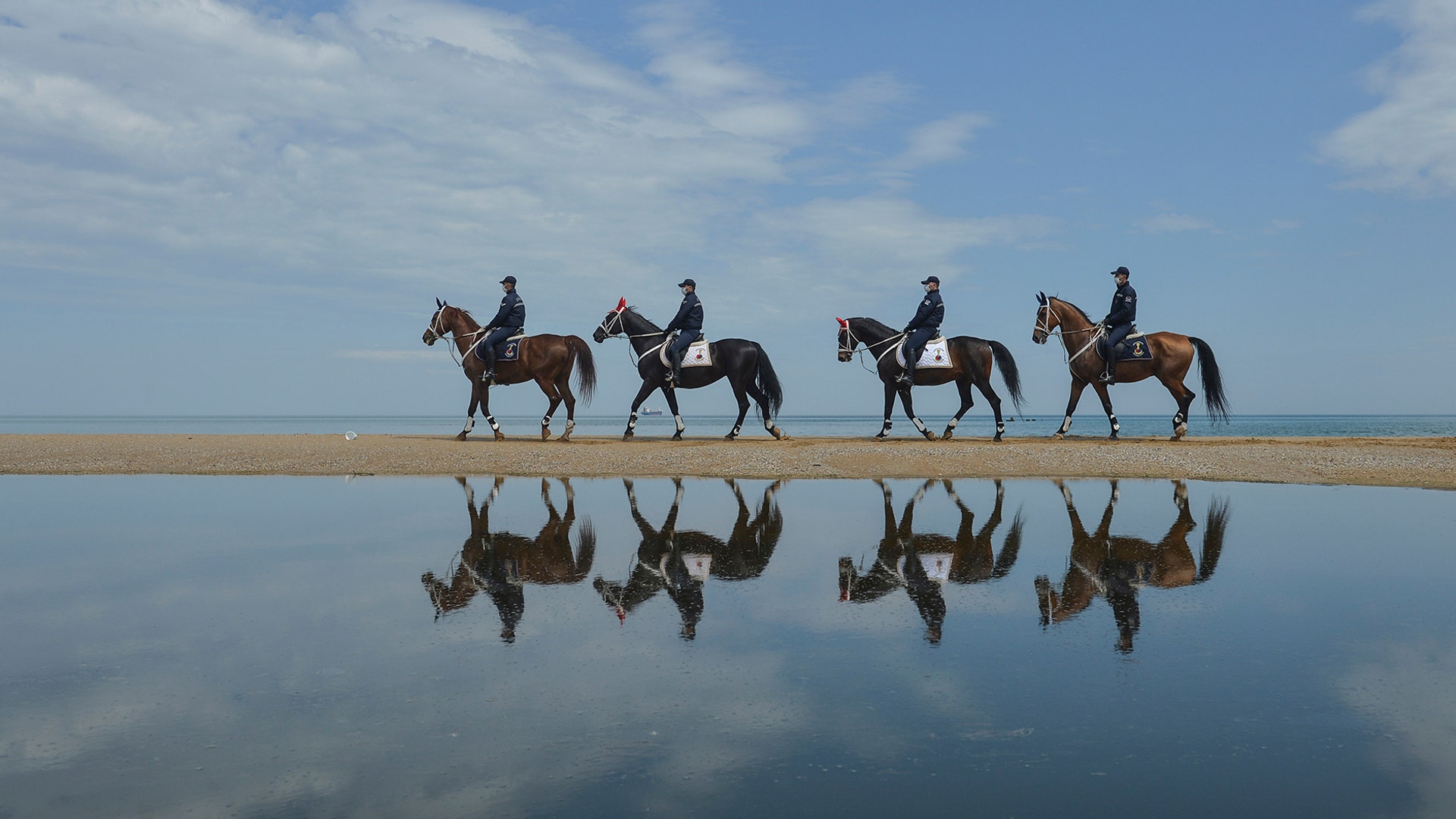 Members of the Equestrian Gendarmerie Units, which normally serve to protect the Topkapı Palace, wearing face masks for protection against the coronavirus patrol the beaches in Sariyer, near Istanbul, May 2, 2020. 