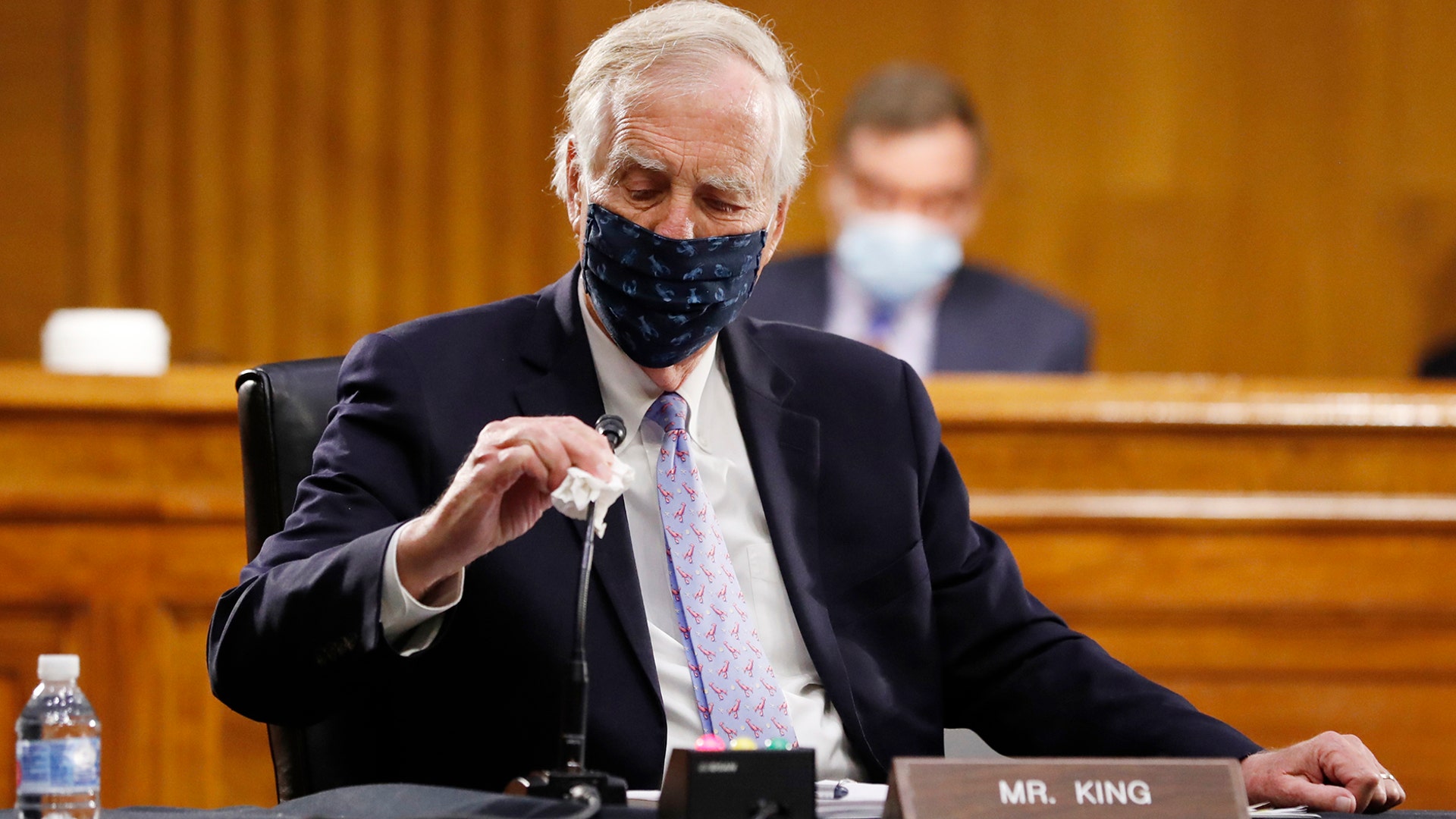Sen. Angus King wipes his microphone as he arrives for a Senate Intelligence Committee nomination hearing for Rep. John Ratcliffe in Washington, May. 5, 2020. 