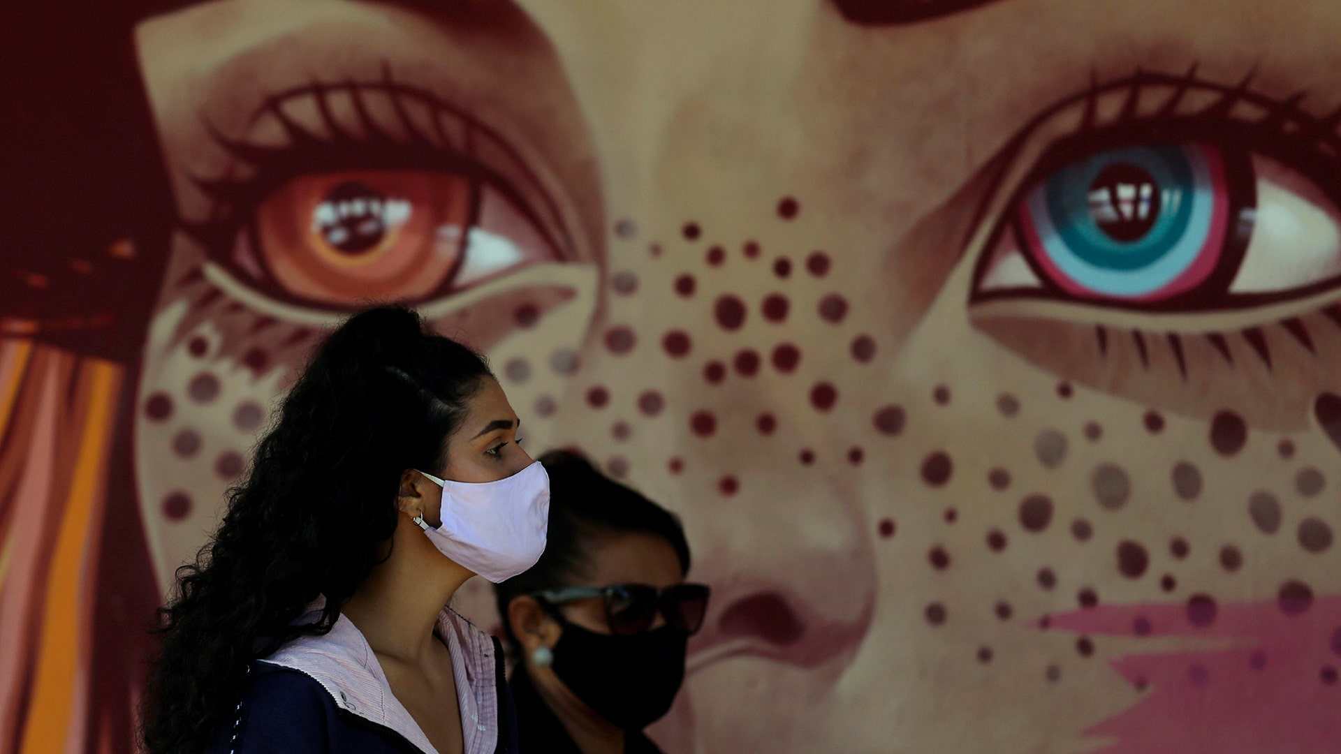 Women wear face masks as they wait for a test at a COVID-19 testing site in the Estrutural neighborhood of Brasilia, Brazil, May 26, 2020. 