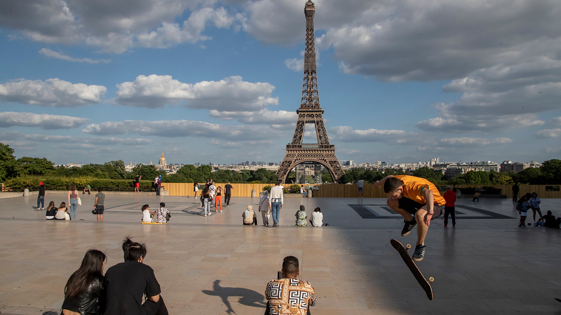 People stroll at Trocadero square near the Eiffel Tower in Paris, May 25, 2020. 