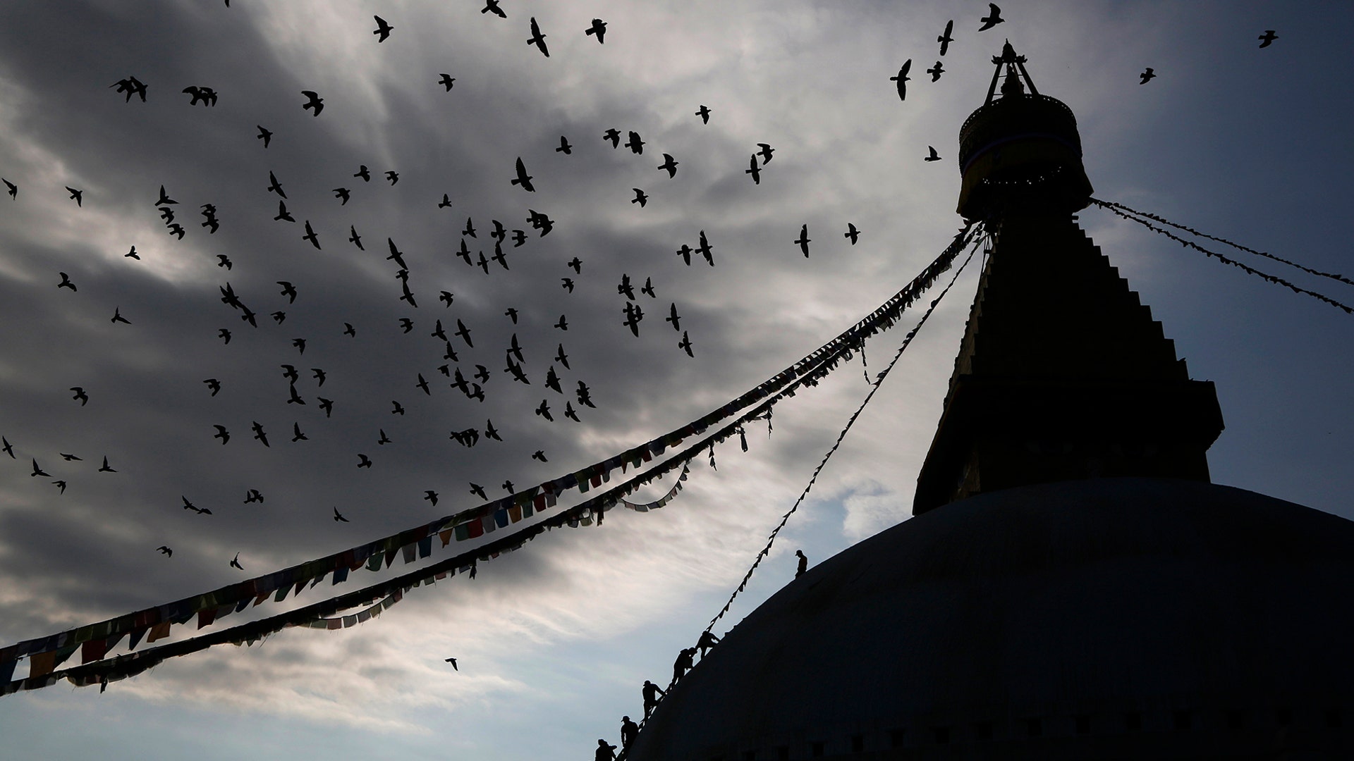 Nepalese workers climb up carrying colored water to splash on to the stupa to celebrate Buddha Jayanti festival during lockdown at Boudhanath Stupa in Kathmandu, Nepal, May 7, 2020.