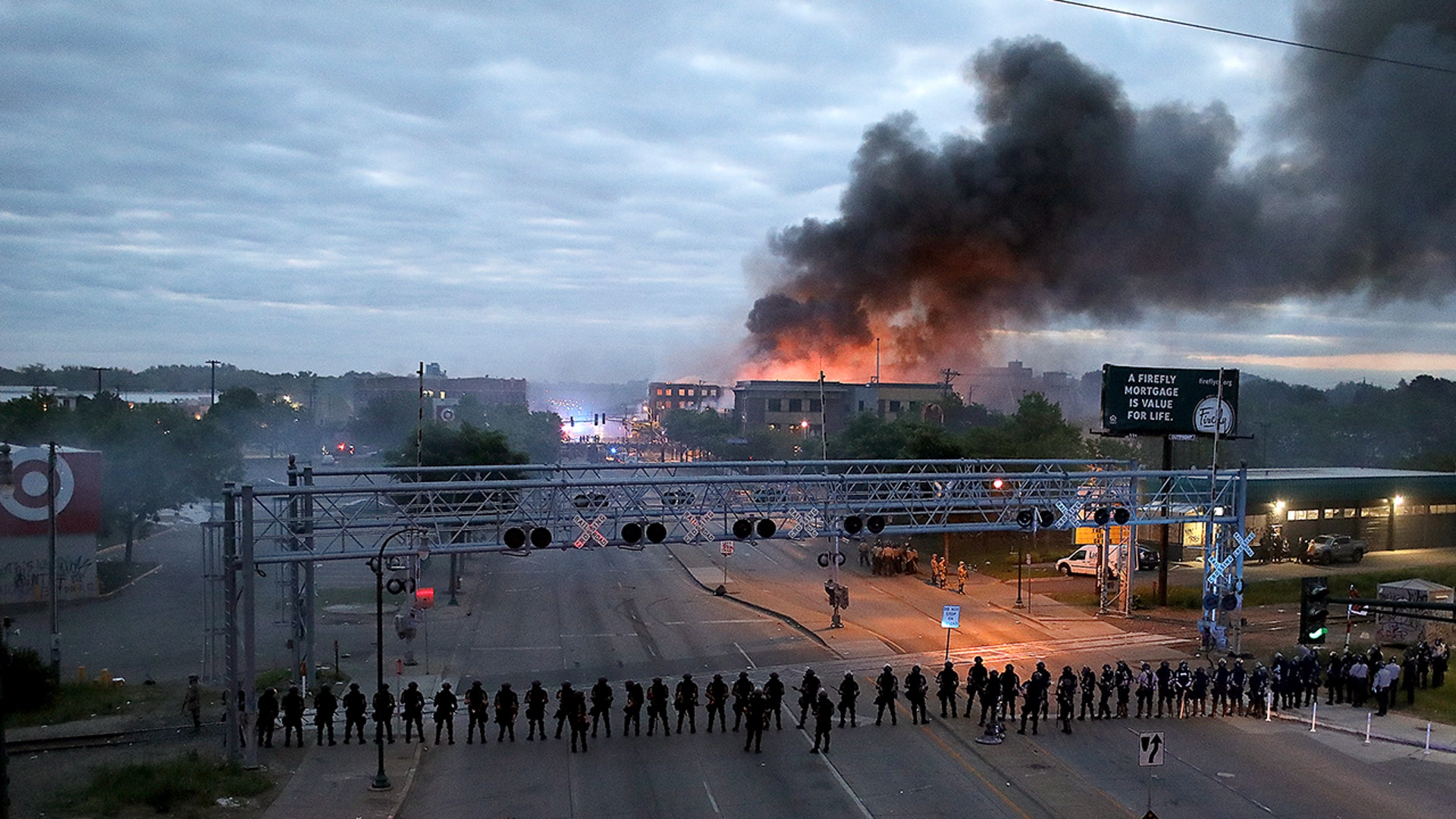 Law enforcement officers amassed along Lake Street near Hiawatha Ave. as fires burned after a night of unrest and protests in the death of George Floyd early Friday, May 29, 2020 in Minneapolis. 