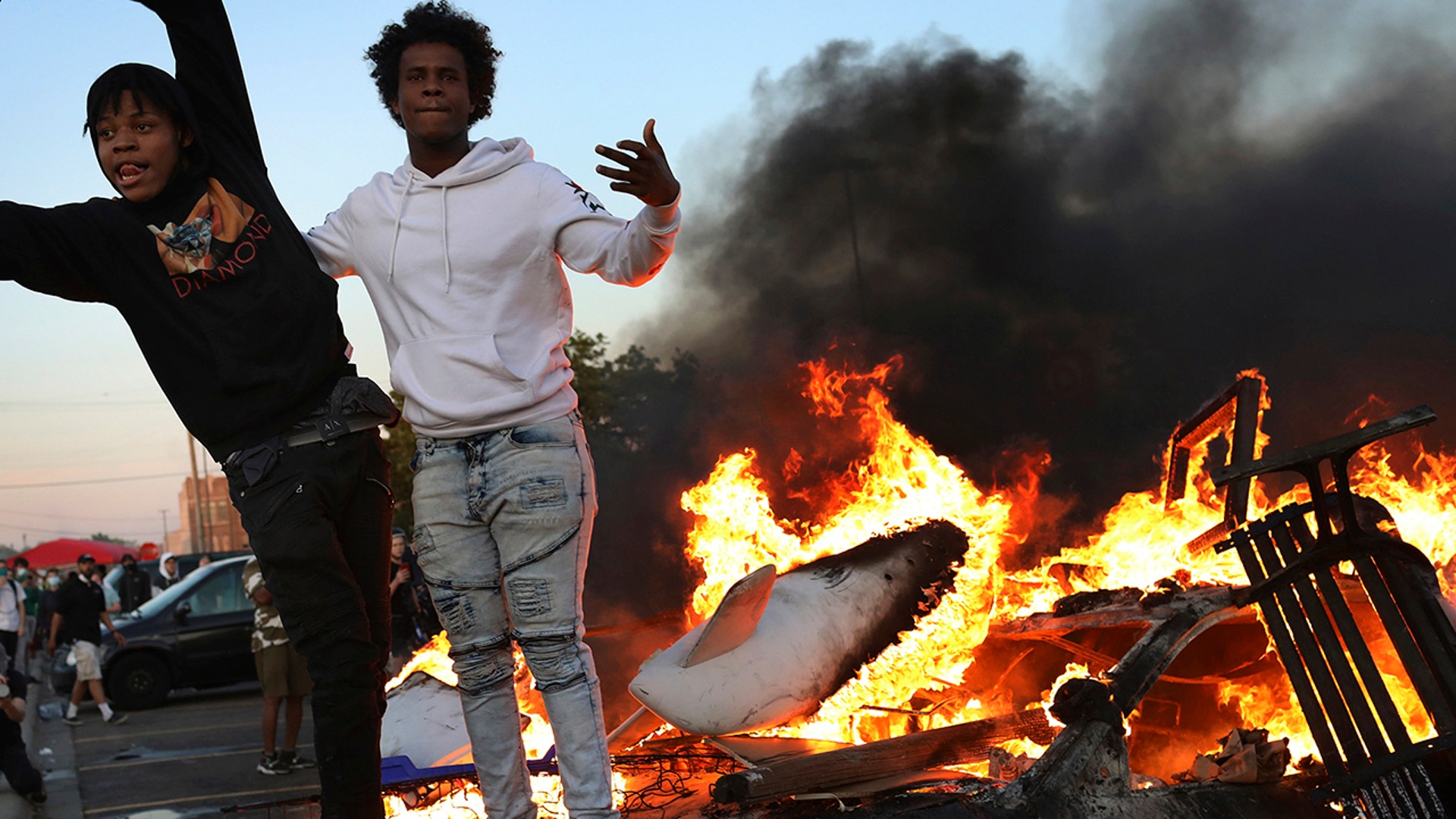 Young men stand atop a burning car in the Target parking lot E. Lake St. during a third night of unrest following the death of George Floyd while in Minneapolis police custody early in the week and seen Thursday, May 28, 2020, in Minneapolis, MN.