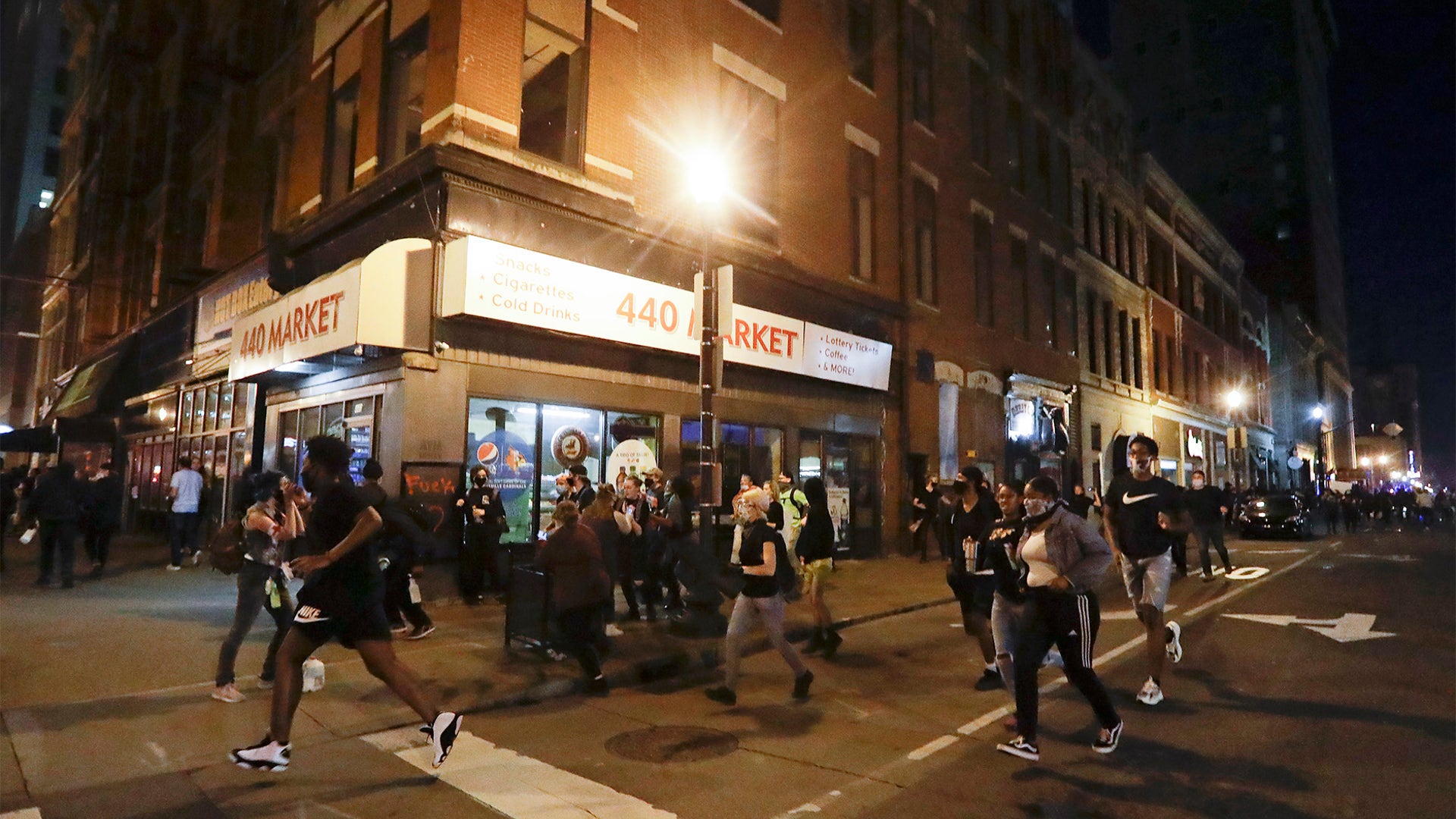 Protesters run after officers fired tear gas during a protest in Louisville.