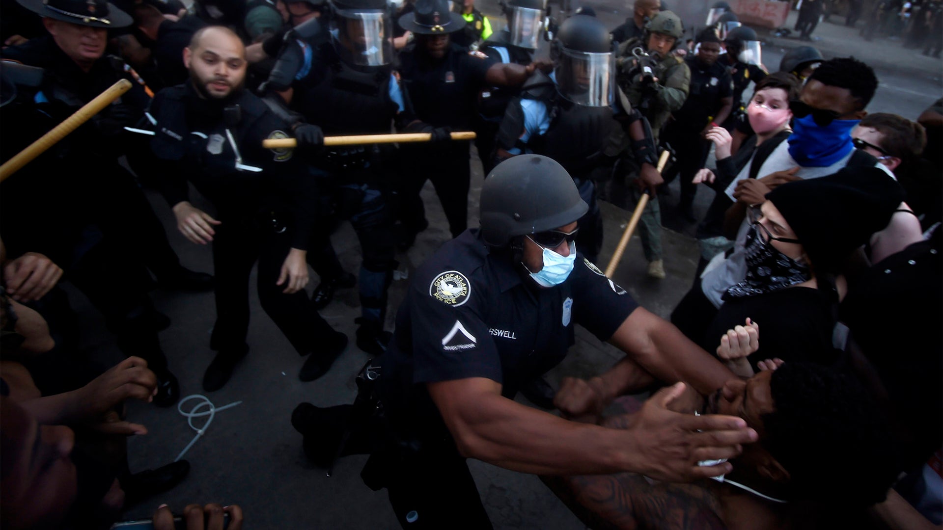 Police officers and protesters clash near CNN Center Friday in Atlanta
