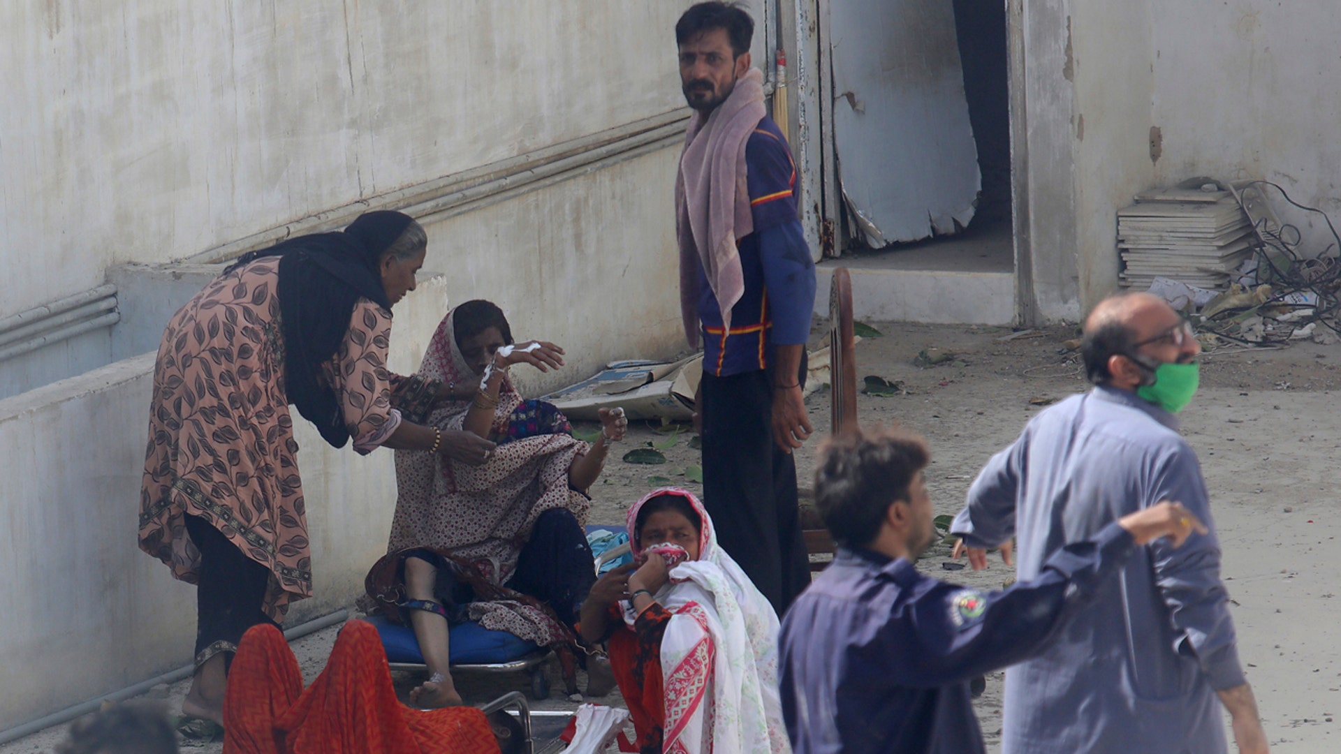 Residents of an area hit by a plane crash wait for medical help in Karachi, Pakistan, Friday, May 22, 2020. (AP Photo/Fareed Khan)
