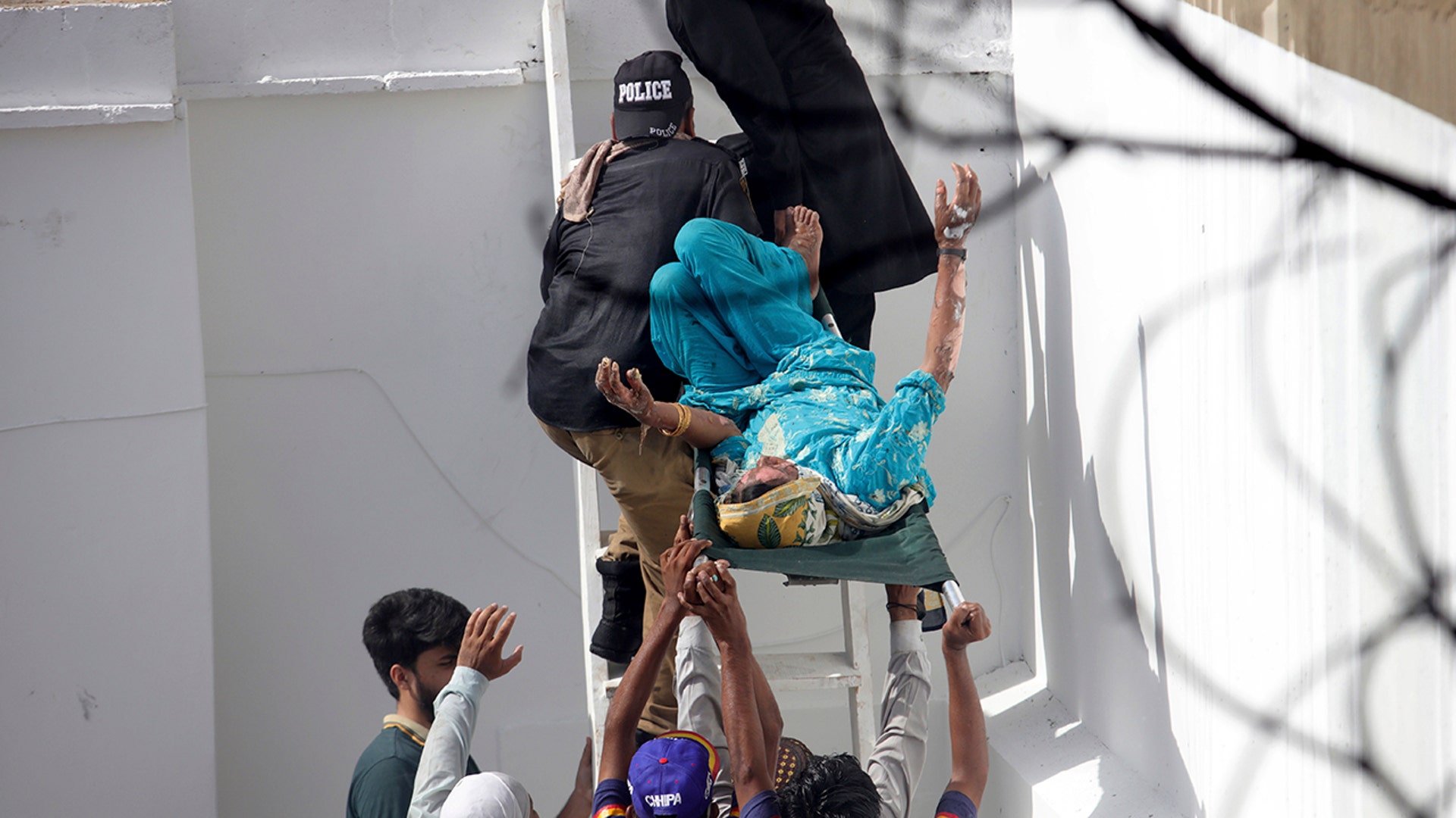 Volunteers carry an injured person at the site of a plane crash in Karachi, Pakistan, Friday, May 22, 2020. (AP Photo/Fareed Khan)