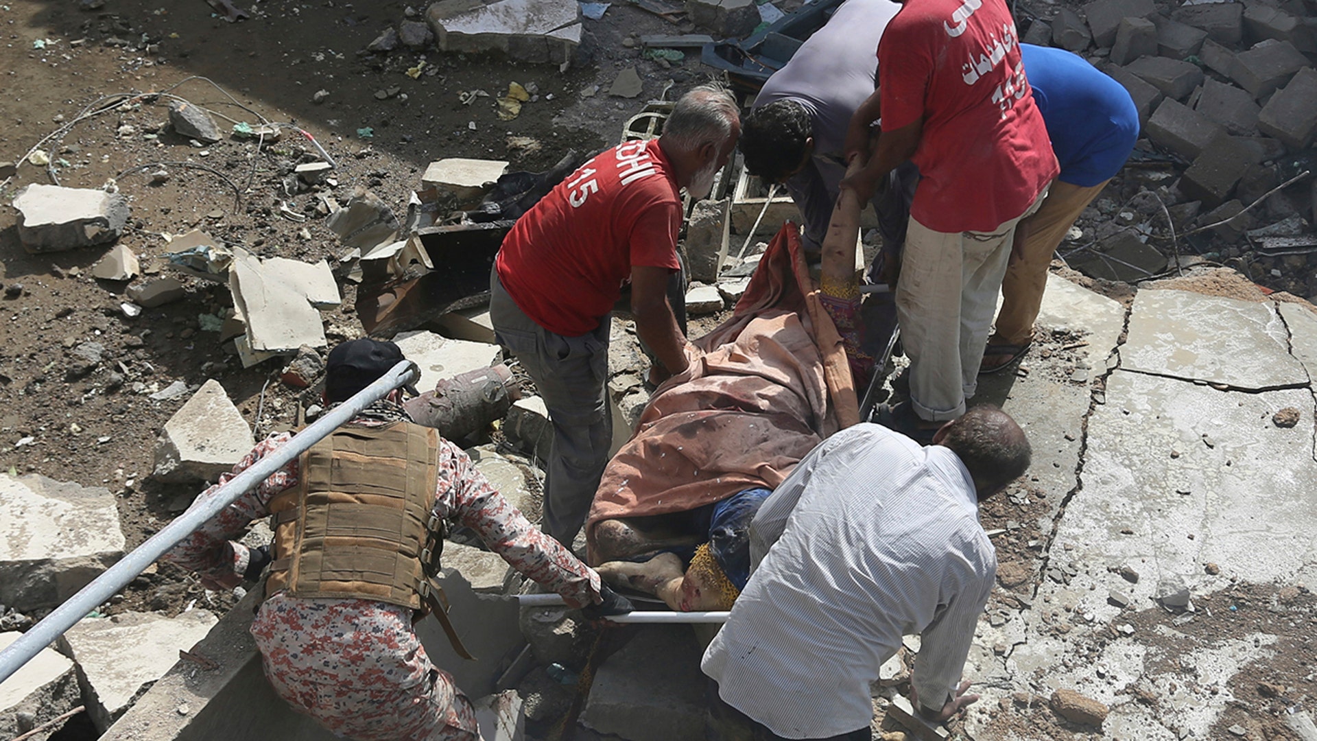 Volunteers carry the dead body of a plane crash victim at the site of a crash in Karachi, Pakistan, Friday, May 22, 2020. (AP Photo/Fareed Khan)