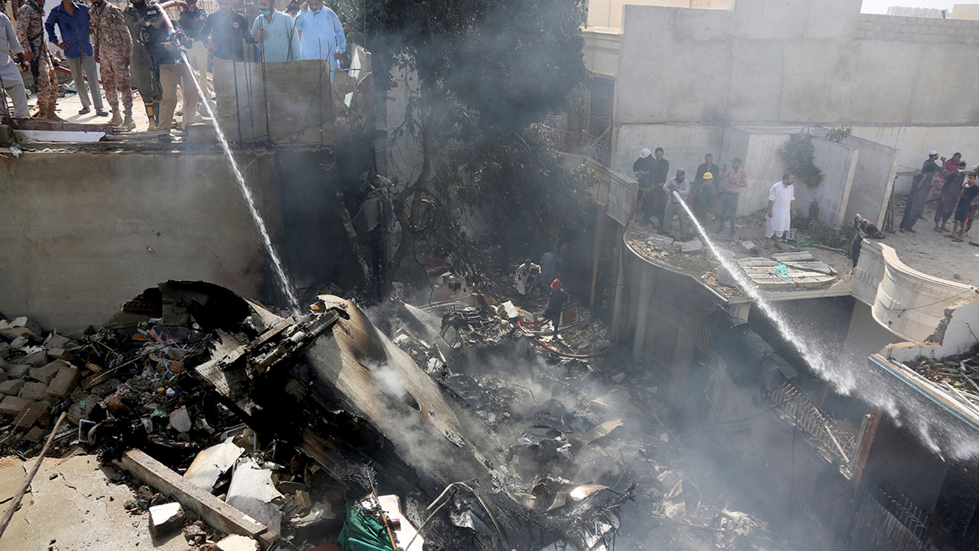 Fire brigade staff try to put out fire caused by plane crash in Karachi, Pakistan, Friday, May 22, 2020. An aviation official says a passenger plane belonging to state-run Pakistan International Airlines carrying more than 100 passengers and crew has crashed near the southern port city of Karachi. There were no immediate reports on the number of casualties. (AP Photo/Fareed Khan)