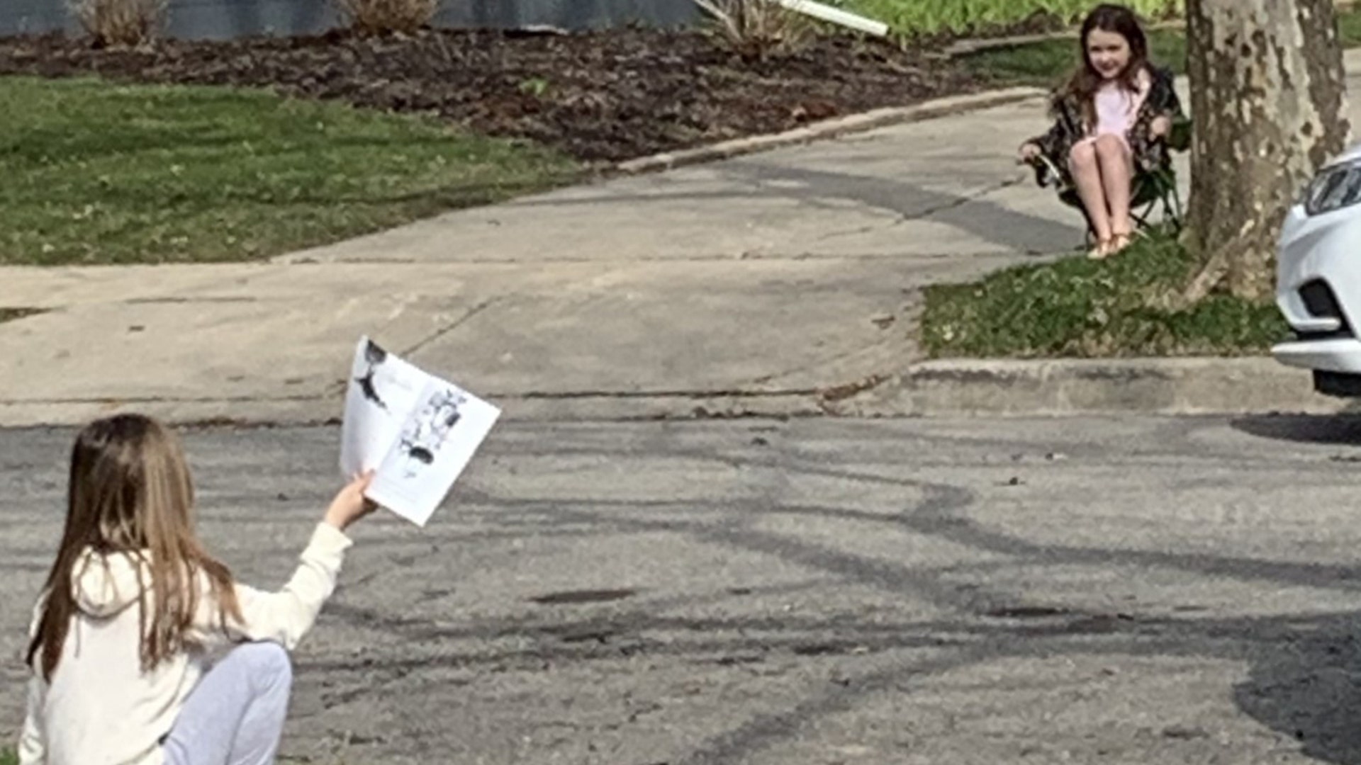 Daphne reads to her friend Mila in Plymouth Mi as every day is a good day to share a story , even if you have to keep your distance