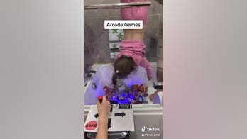 Dad recreates arcade claw game in own bathtub, hangs daughter upside down to act as 'grabber'