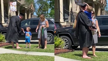 Boy, 3, hands dad MBA diploma during front lawn graduation ceremony