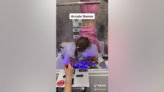 Dad recreates arcade claw game in own bathtub, hangs daughter upside down to act as 'grabber'