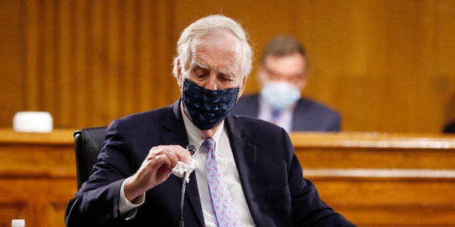 Sen. Angus King, I-Maine, wipes his microphone as he arrives for a Senate Intelligence Committee nomination hearing for Rep. John Ratcliffe, R-Texas, on Capitol Hill in Washington, Tuesday, May. 5, 2020. (AP Photo/Andrew Harnik, Pool)