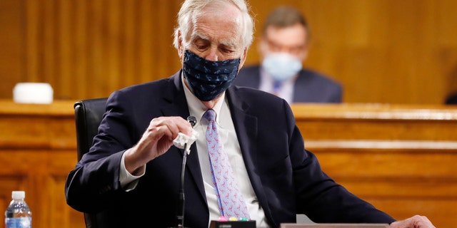 Sen. Angus King, I-Maine, wipes his microphone as he arrives for a Senate Intelligence Committee nomination hearing for Rep. John Ratcliffe, R-Texas, on Capitol Hill in Washington, Tuesday, May. 5, 2020. (AP Photo/Andrew Harnik, Pool)