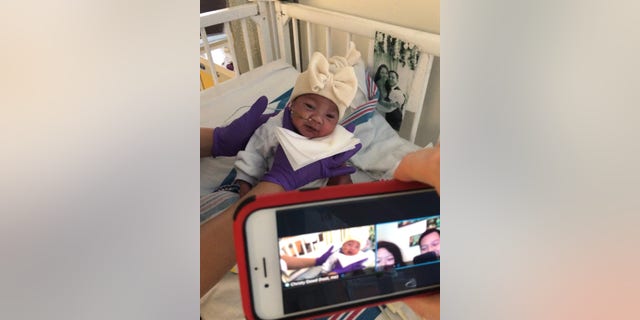 A child life specialist (Christy Dowd) conducts a virtual visit with patient, Mya, and her parents, Kristal and Mike, from the neonatal intensive care unit (NICU) at NewYork-Presbyterian Morgan Stanley Children’s Hospital.