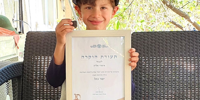 Imri Elya with the ancient tablet and the certificate of recognition given to him by the Israel Antiquities Authority.