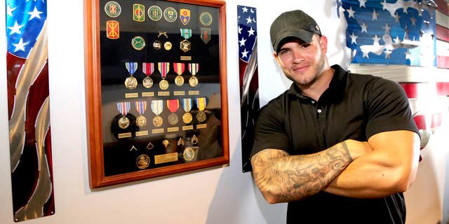 Colin Wayne next to medals he received for combat. 
