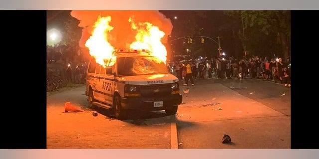 A police van goes up in flames in New York City. 