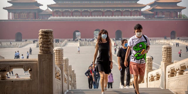 Visitors wearing face masks to protect against the new coronavirus walk through the Forbidden City in Beijing, Friday, May 1, 2020. (Associated Press)