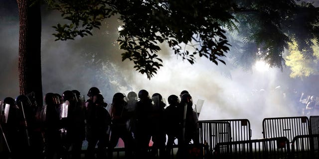 Police stage in Lafayette Park as demonstrators gather to protest the death of George Floyd, Sunday, May 31, 2020, near the White House in Washington. Floyd died after being restrained by Minneapolis police officers (AP Photo/Alex Brandon)