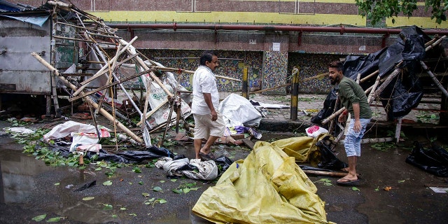 Roadside vendors along a metro station salvage material from his stall after Cyclone Amphan hit the region in Kolkata, India, Thursday, May 21, 2020. A powerful cyclone ripped through densely populated coastal India and Bangladesh.