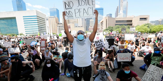 Protesters demonstrate police brutality in front of Dallas City Hall in downtown Dallas, Saturday, May 30, 2020. Protests across the country have escalated over the death of George Floyd who died after being restrained by Minneapolis police officers on Memorial Day. (AP Photo/LM Otero)