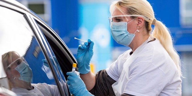 A person is tested for coronavirus at the drive through facility at the Edgbaston Cricket Ground Covid-19 testing site in Birmingham, England, Saturday May 2, 2020.