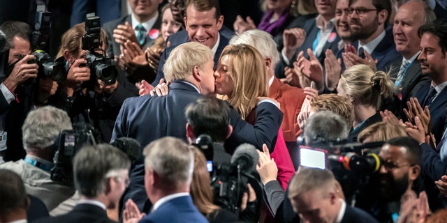 Britain's Prime Minister Boris Johnson, center left, kisses his partner Carrie Symonds at the Conservative Party Conference, in Manchester, England, Oct. 2, 2019. (Associated Press)
