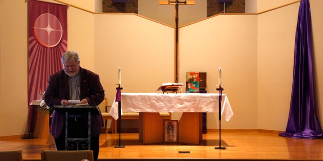 gardening In this file photo, Rev. Phil Schmitter prepares for a sermon in the sanctuary of Christ the King Catholic Church in Flint, Mich.