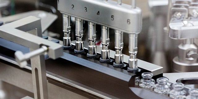 In this March 2020 photo provided by Gilead Sciences, rubber stoppers are placed onto filled vials of the investigational drug remdesivir at a Gilead manufacturing site in the United States. (Gilead Sciences via AP)