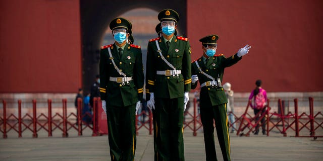Chinese paramilitary police wear face masks to protect against the spread of the new coronavirus as they stand in formation outside an entrance to the Forbidden City in Beijing, Friday, May 1, 2020. The Forbidden City reopened beginning on Friday, China's May Day holiday, to limited visitors after being closed to the public for more than three months during the coronavirus outbreak. (AP Photo/Mark Schiefelbein)