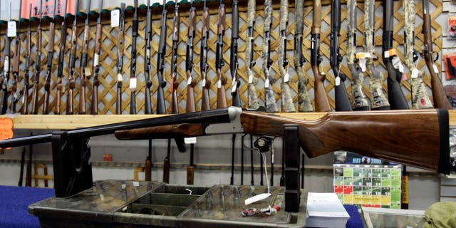 FILE - In a May 16, 2006 file photo, rifles line a hunting store's shelves in Ottawa. Prime Minister Justin Trudeau said Friday, May 1, 2020 that Canada is banning the use and trade of assault-style weapons immediately. (Jonathan Hayward/The Canadian Press via AP)