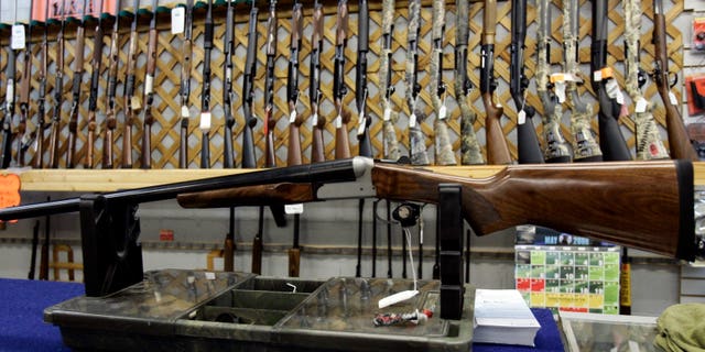 FILE - In a May 16, 2006 file photo, rifles line a hunting store's shelves in Ottawa. Prime Minister Justin Trudeau said Friday, May 1, 2020 that Canada is banning the use and trade of assault-style weapons immediately. (Jonathan Hayward/The Canadian Press via AP)