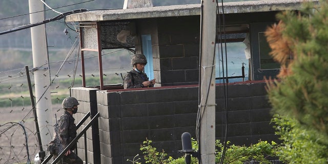 Army soldiers walk up the stairs of their military guard post in Paju, South Korea, near the border with North Korea on Sunday. North and South Korean troops exchanged fire along their tense border on Sunday, the South's military said, blaming North Korean soldiers for targeting a guard post. (AP Photo/Ahn Young-joon)