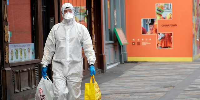 A man wears full protective equipment to protect against the coronavirus as he shops in London, Monday, May 4, 2020, as the UK enters a seventh week of lockdown to help stop the spread of coronavirus. The highly contagious COVID-19 has impacted on nations around the globe, many imposing self isolation and exercising social distancing when people move from their homes. 