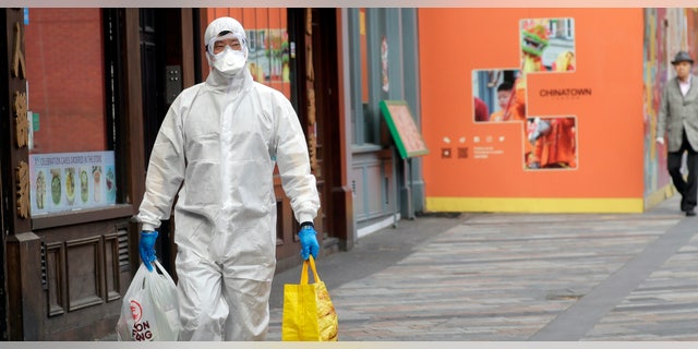 A man wears full protective equipment to protect against the coronavirus as he shops in London, Monday, May 4, 2020, as the UK enters a seventh week of lockdown to help stop the spread of coronavirus. The highly contagious COVID-19 has impacted on nations around the globe, many imposing self isolation and exercising social distancing when people move from their homes.