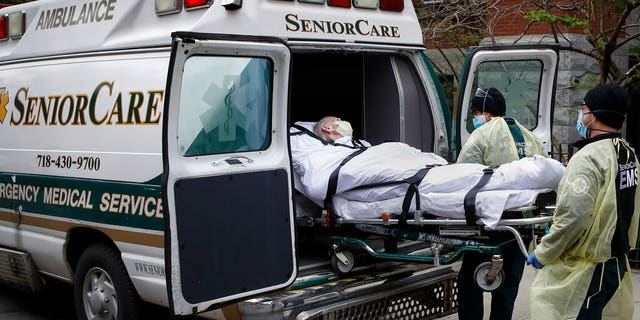 FILE - In this April 17, 2020, file photo, a patient is loaded into an ambulance by emergency medical workers outside Cobble Hill Health Center in the Brooklyn borough of New York. New York state is now reporting more than 1,700 previously undisclosed deaths at nursing homes and adult care facilities as the state faces scrutiny over how it’s protected vulnerable residents during the coronavirus pandemic. (AP Photo/John Minchillo, File)