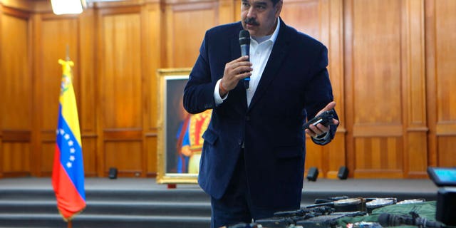 This photo released by the Venezuelan Miraflores presidential press office shows President Nicolas Maduro speaking over military equipment that he says was seized during an incursion into Venezuela, during his televised address from Miraflores in Caracas, Venezuela, Monday, May 4, 2020.