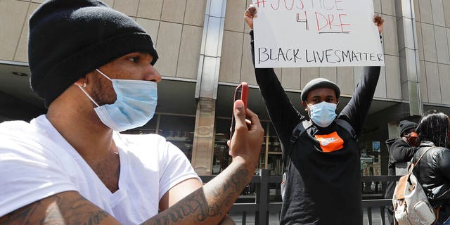 A protester holds a sign outside of the City County Building, Thursday, May 7, 2020, in Indianapolis. The crowd was protesting the fatal shooting Wednesday evening by an Indianapolis Metropolitan Police Officer. (AP Photo/Darron Cummings)