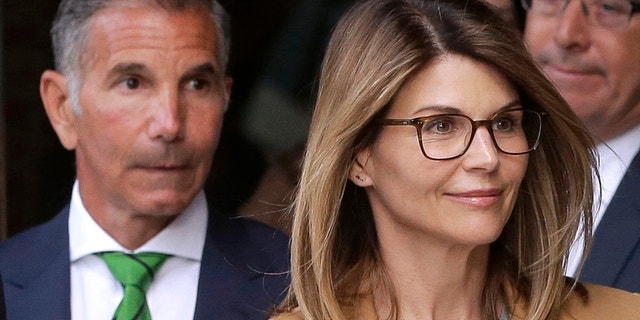 In this April 3, 2019, file photo, actress Lori Loughlin, front, and her husband, clothing designer Mossimo Giannulli, left, depart federal court in Boston after a hearing in a nationwide college admissions bribery scandal. A federal judge on Friday, May 8, 2020, refused to dismiss charges against the couple and other prominent parents accused of cheating in the college admissions process, siding with prosecutors who denied that investigators had fabricated evidence. (AP Photo/Steven Senne