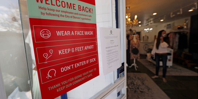 A placard of rules for customers to follow hangs on the door of a boutique as retail businesses are allowed to open their doors to customers for the first time in almost two months with the expiration of the city's stay-at-home order to check the spread of the new coronavirus Saturday, May 9, 2020, in Denver. (AP Photo/David Zalubowski)