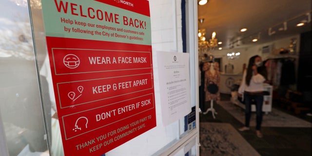 A placard of rules for customers to follow hangs on the door of a boutique as retail businesses are allowed to open their doors to customers for the first time in almost two months with the expiration of the city's stay-at-home order to check the spread of the new coronavirus Saturday, May 9, 2020, in Denver. (AP Photo/David Zalubowski)