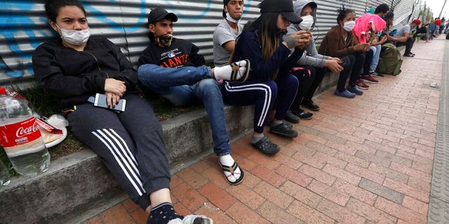 In this April 30, 2020 photo, Venezuelan migrants wait for buses that will transport them to the Venezuelan border, in Bogota, Colombia.