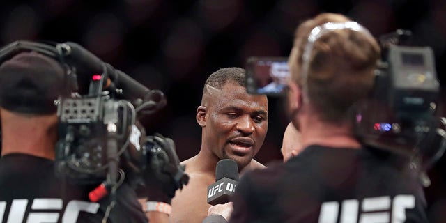 Francis Ngannou, center, is interviewed after winning a UFC 249 mixed martial arts bout against Jairzinho Rozenstruik, Saturday, May 9, 2020, in Jacksonville, Fla. (Associated Press)