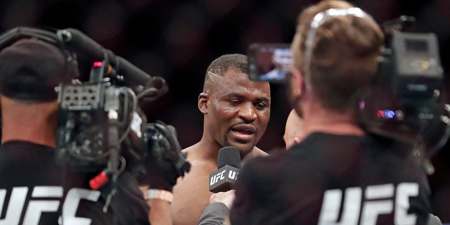 Francis Ngannou, center, is interviewed after winning a UFC 249 mixed martial arts bout against Jairzinho Rozenstruik, Saturday, May 9, 2020, in Jacksonville, Fla. (Associated Press)